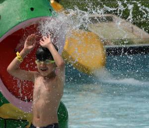 A boy plays in a swimming pool at a wate
