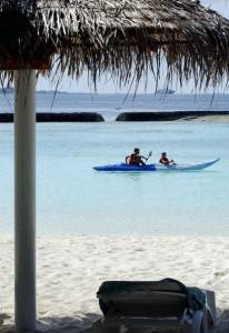 Foreign tourist children paddle a kayak