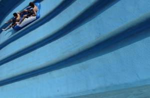 Young boys cost on a toboggan at water p