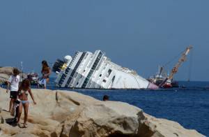 Tourists sunbathe as salvage team member
