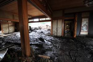 Mud from a landslide flows through a hou