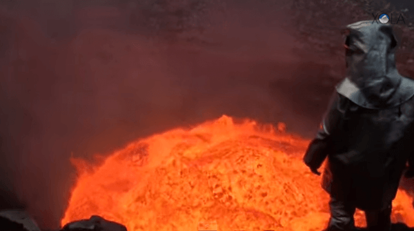 Uomo nel cratere di un vulcano attivo