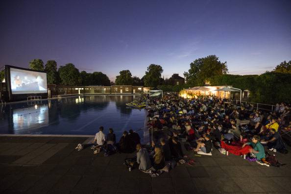 LONDON, ENGLAND - JULY 17: Members of the public watch an outdoor screening of the film 'Jaws' in Brockwell Lido at night on July 17, 2014 in London, England. The outdoor screening was arranged by 'The Luna Cinema' who show classic films on big screens in interesting settings such as: parks, manor houses, castles, swimming pools, theatres and ruined abbeys. (Photo by Oli Scarff/Getty Images)