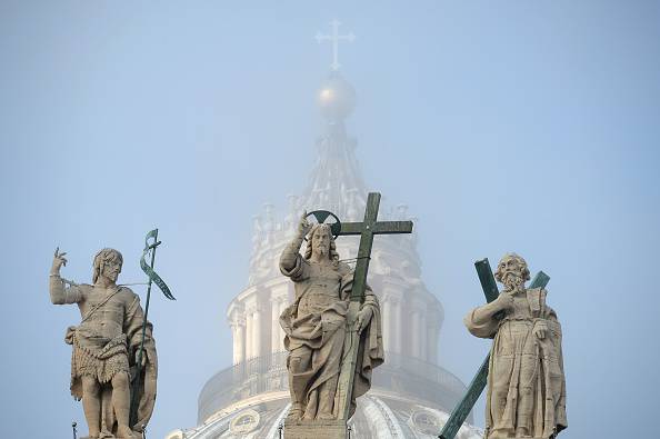 The statues at the top of St Peter's basilica are in the fog during the weekly general audience of Pope Francis at St Peter's square on November 11, 2015 at the Vatican. AFP PHOTO / VINCENZO PINTO (Photo credit should read VINCENZO PINTO/AFP/Getty Images)