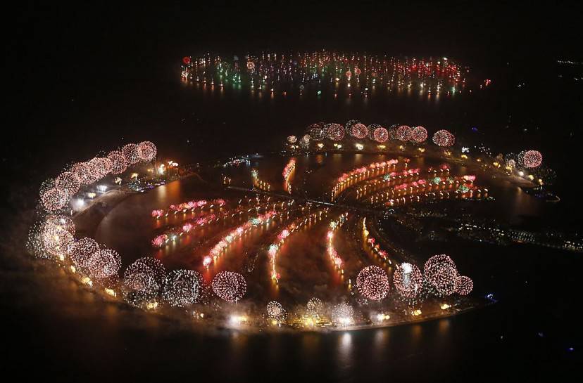 Fireworks explode over Palm Jumeirah in Dubai on January 1, 2014 to celebrate the new year. Dubai kicked off New Year with a dazzling bid for a new world record to cap those the Gulf city state already holds for its mammoth property developments. The glittering fireworks display that lasted around six minutes spanned over 100 kilometres (60 miles) of the Dubai coast, which boasts an archipelago of man-made islands and Burj Khalifa, the world's tallest tower. AFP PHOTO / KARIM SAHIB (Photo credit should read KARIM SAHIB/AFP/Getty Images)