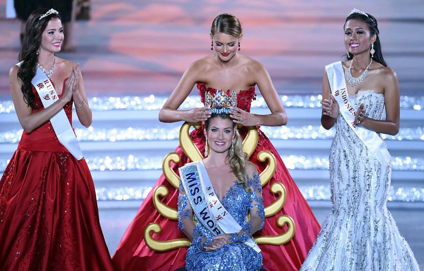 Mireia Lalaguna (C) of Spain is crowned by former Miss World Jolene Strauss after winning the new title at the Miss World Grand Final in Sanya, next to Miss Russia Sofia Nikitchuk (L) and Miss World Indonesia Maria Harfanti (R) in southern China's Hainan province on December 19, 2015. Contestants from over 110 countries compete in the final of the 65th Miss World Competition. AFP PHOTO / JOHANNES EISELE / AFP / JOHANNES EISELE (Photo credit should read JOHANNES EISELE/AFP/Getty Images)