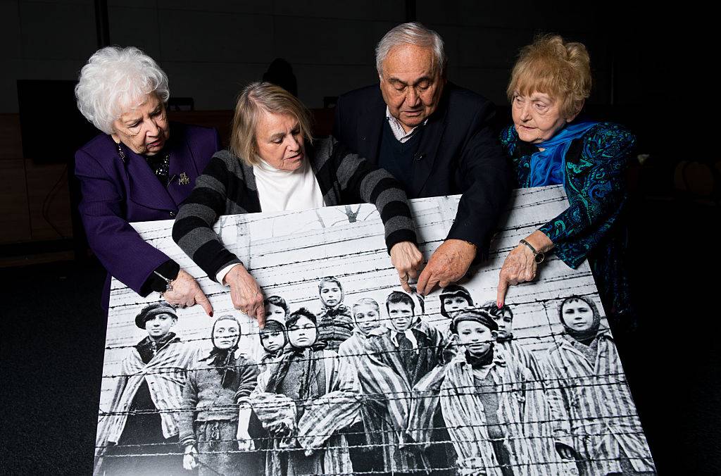 KRAKOW, POLAND - JANUARY 26:  (L-R) 79-year-old Miriam Ziegler, 81-year-old Paula Lebovics, 85-year-old Gabor Hirsch and 80-year-old Eva Kor pose with the original image of them as children taken at Auschwitz at the time of its liberation on January 26, 2015 in Krakow, Poland. This week marks the 70th anniversary of the liberation of Auschwitz and to mark the event USC Shoah Foundation have brought together, for the first time, four of the survivors from the iconic image by Alexander Vorontsov of Auschwitz children. Auschwitz was among the most notorious of the extermination camps run by the Nazis to enslave and kill millions of Jews, political opponents, prisoners of war, homosexuals and Roma.  (Photo by Ian Gavan/Getty Images)