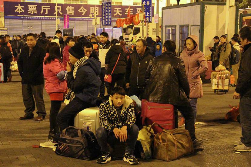 In this photograph taken on February 2, 2016, stranded travellers sit with their luggage at a train station in Guangzhou as they prepare to head home for the upcoming Lunar New Year. Tens of thousands of Lunar New Year travellers in China were stranded February 2 at a station in Guangzhou, state media said, after snow and ice elsewhere disrupted the world's largest annual human migration. AFP PHOTO / AFP / STR        (Photo credit should read STR/AFP/Getty Images)