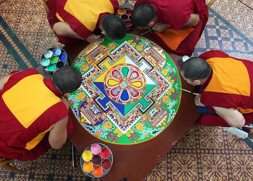 SALISBURY, ENGLAND - OCTOBER 03: Tibetan Monks from the Tashi Lhunpo Monastery , (clockwise from top) Ven Lobzang Thokmed, Kachen Namgyal, Kachen Lobzang Tuskhor and Kachen Choedrak complete a Chenrezig Sand Mandala in Salisbury Cathedrals Chapter House on October 3, 2013 in Salisbury, England. The monks, who started the painstaking process of creating the sand mandela with millions of grains of coloured sand on Monday, will end it tomorrow in a destruction ceremony and procession to the River Avon. The monks who currently live in exile in India are visiting various places in the UK and Europe and will complete two more sand mandelas - which are an artistic tradition of Tibetan Buddhism and are a symbolic picture of the universe representing an imaginary palace - before returning home to their monastery in late November. (Photo by Matt Cardy/Getty Images)