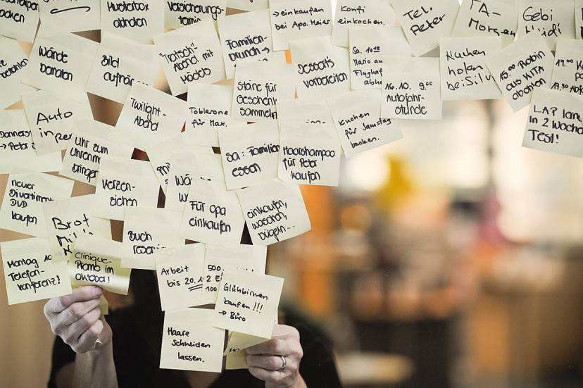 A woman removes some post-it notes, with common tasks to remember written on them,  on a chemist's window in Winterthur on November 7, 2013.         (Photo credit should read SEBASTIEN BOZON/AFP/Getty Images)