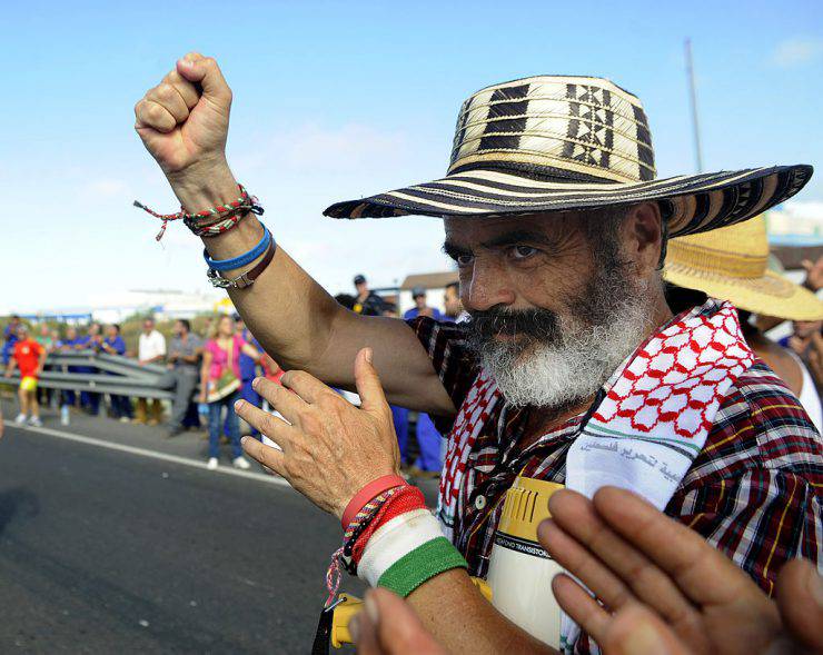 Manuel Sanchez Gordillo, mayor of Marinaleda and member of the regional Andalusian parliament representing the United Left (IU) party, raises his fist as he walks alongside Cadiz shipyard workers during a demonstration march from Puerto Real to Cadiz to denounce the Spanish government's handling of the economic crisis and its latest austerity measures, on August 28, 2012. In Andalucia, a region particularly hard hit by recession due to the collapse of the local construction industry, the unemployment rate is nearly 34 percent, higher than Spain's overall rate of roughly 25 percent. AFP PHOTO / CRISTINA QUICLER        (Photo credit should read CRISTINA QUICLER/AFP/GettyImages)