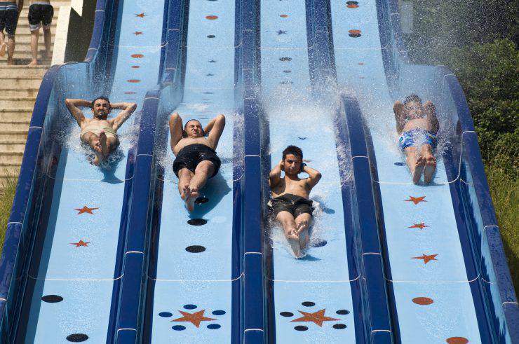 Boys having fun on a pool slide