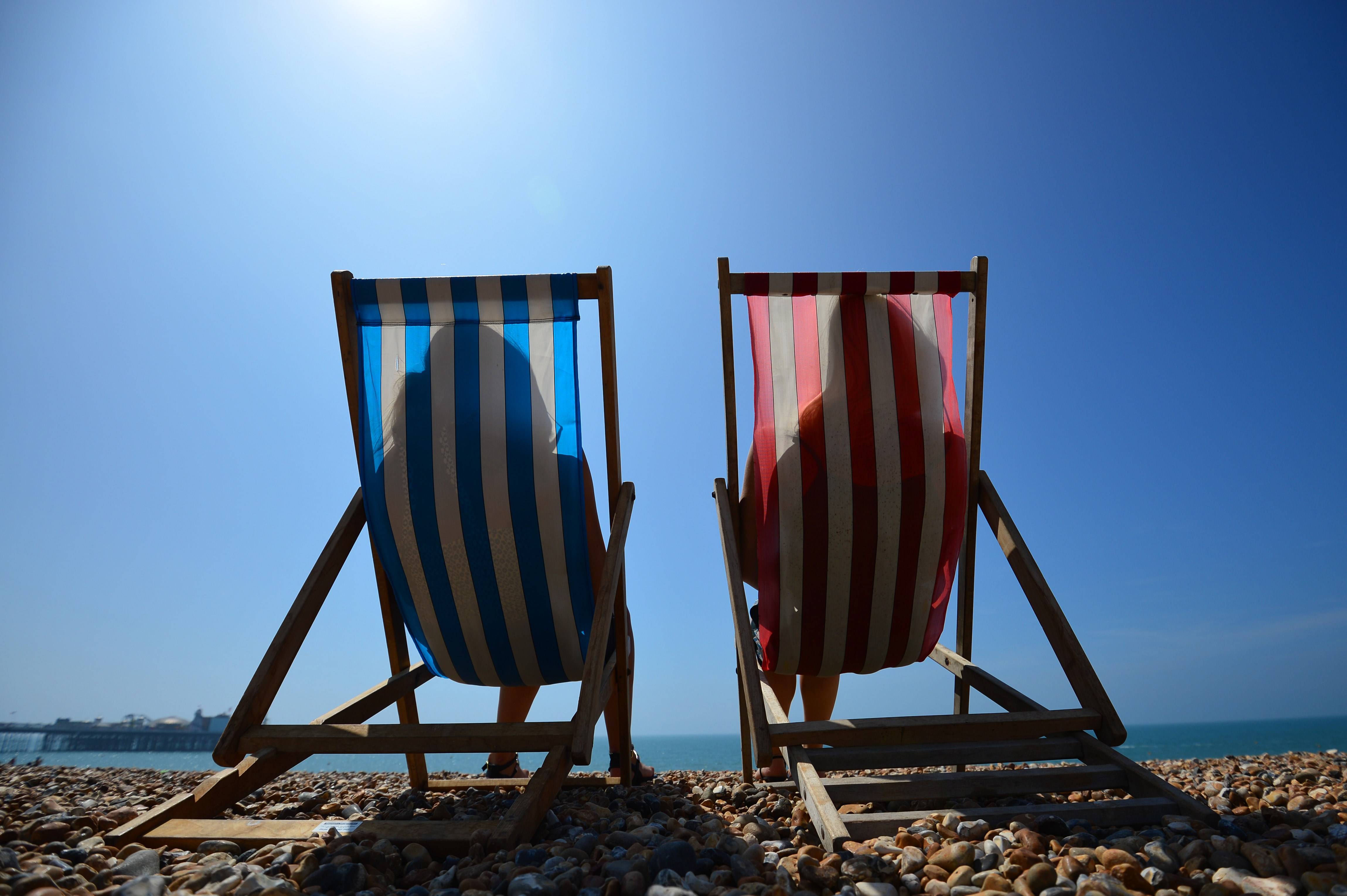 People relax in deck chairs on the beach in Brighton on July 18, 2014, as parts of the country were expected to experience the hottest day of the year so far and the Met Office issued a heatwave alert for southern England and the Midlands.  AFP PHOTO / CARL COURT        (Photo credit should read CARL COURT/AFP/Getty Images)