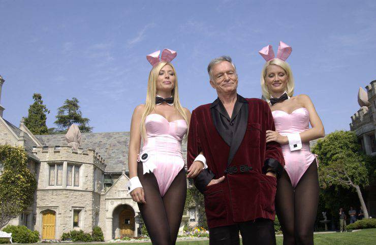 HOLMBY HILLS, CA - MAY 6: (L to R) Playboy bunny Sheila Levell, Playboy founder Hugh Hefner and Playboy bunny Holly Madison perform a scene during the filming of a commercial for "X Games IX" at the Playboy Mansion May 6, 2003 in Holmby Hills, California. This year's X Games will take place at STAPLES Center in Los Angeles from August 14th through 18th. (Photo by Robert Mora/Getty Images)