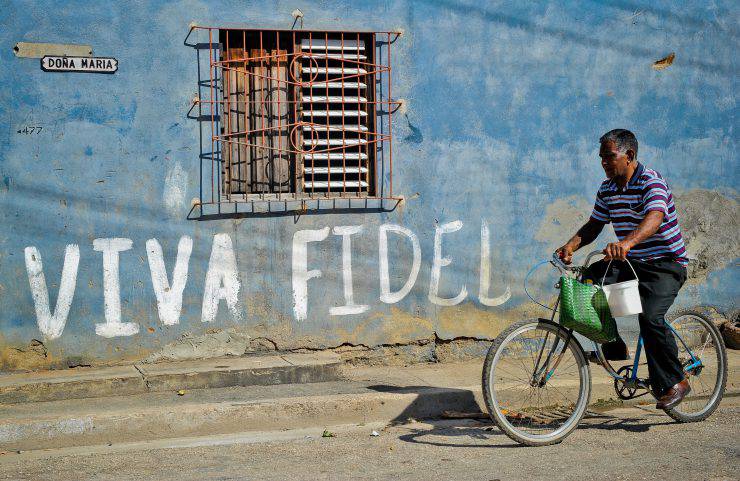 A Cuban rides his bicycle by a graffiti hailing Cuban former president Fidel Castro, on August 12, 2014 in Havana.  Fidel Castro will be 88 on Wednesday     AFP PHOTO/YAMIL LAGE   Fidel Castro will be 88 on Wednesday.       AFP PHOTO/YAMIL LAGE        (Photo credit should read YAMIL LAGE/AFP/Getty Images)