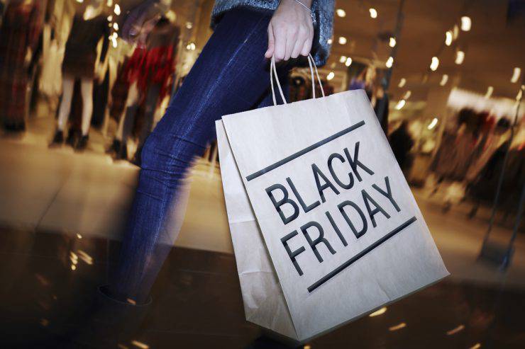 Modern shopper with Black Friday paperbag going in the mall