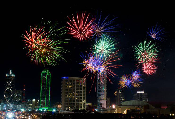 Colorful fireworks display in Dallas, Texas celebrating New Years Eve. Business district and office buildings in background.