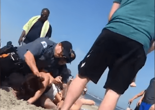 In spiaggia con marito e figlia piccola, picchiata brutalmente dalla polizia - VIDEO