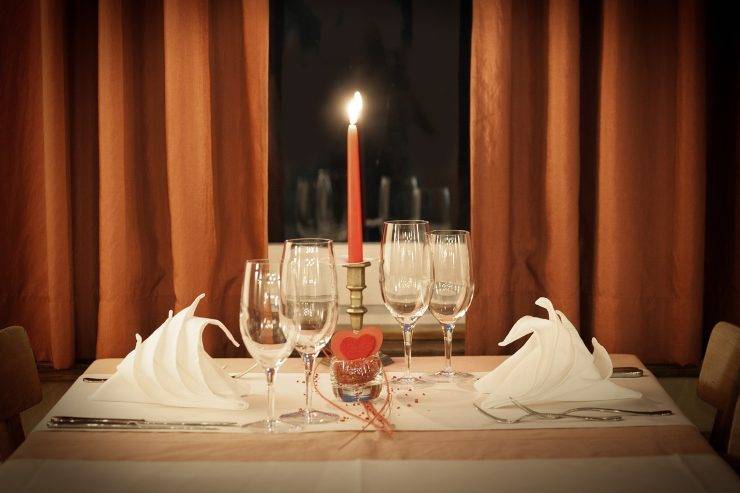 Tavola apparecchiata al ristorante con candela per San Valentino