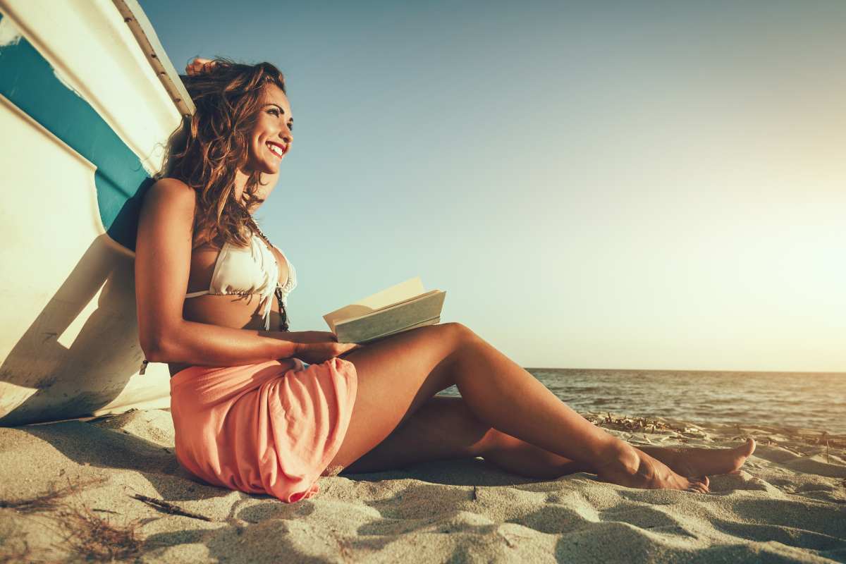 ragazza legge un libro in spiaggia