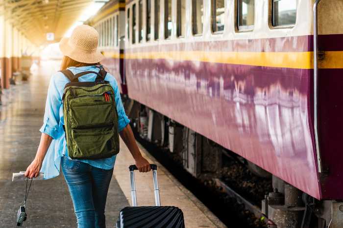 Ragazza con le valige prende il treno per le vacanze di settembre