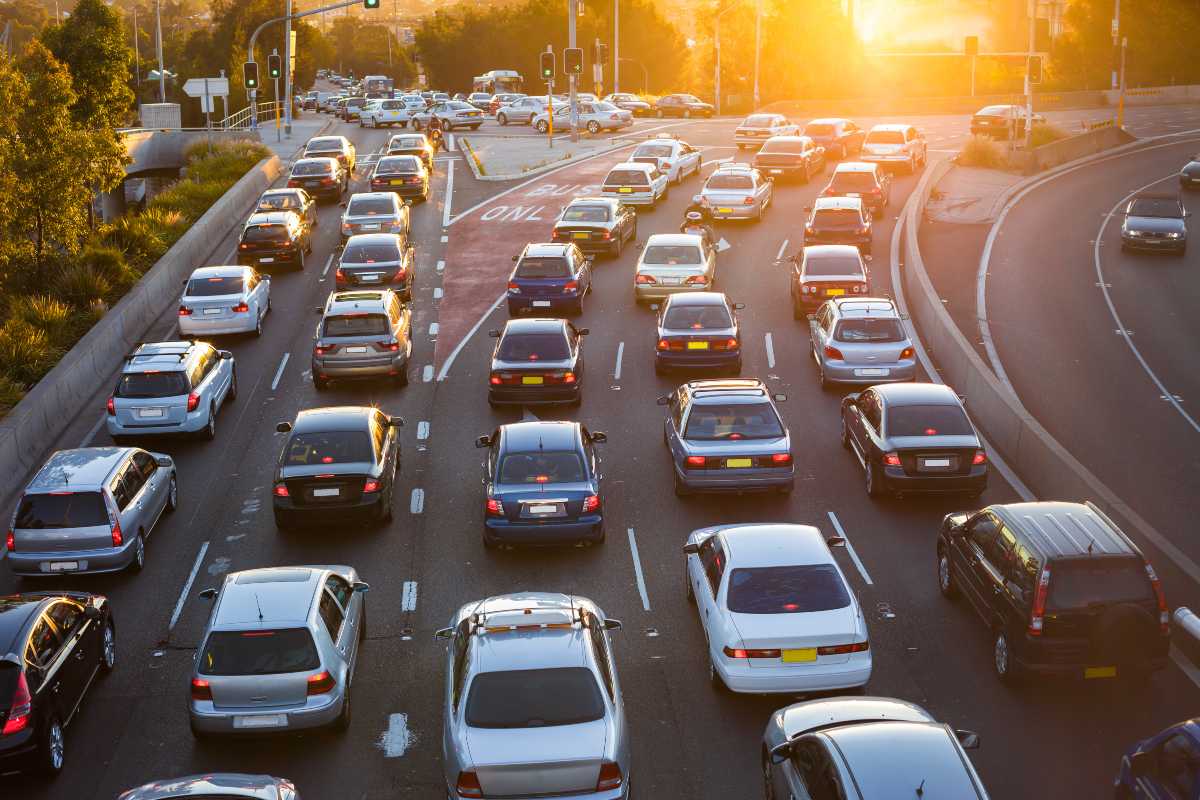 5 file di auto ferme per traffico sull'autostrada al tramonto