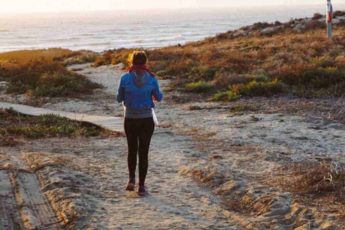 Donna passeggia in riva al mare