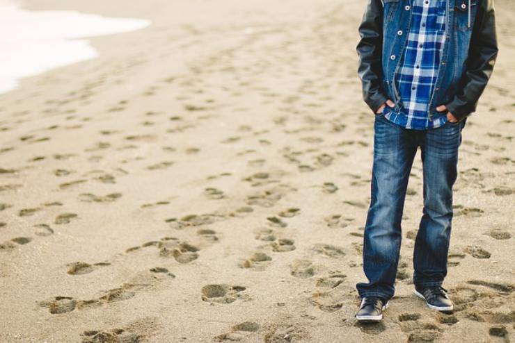 Uomo passeggia in riva al mare