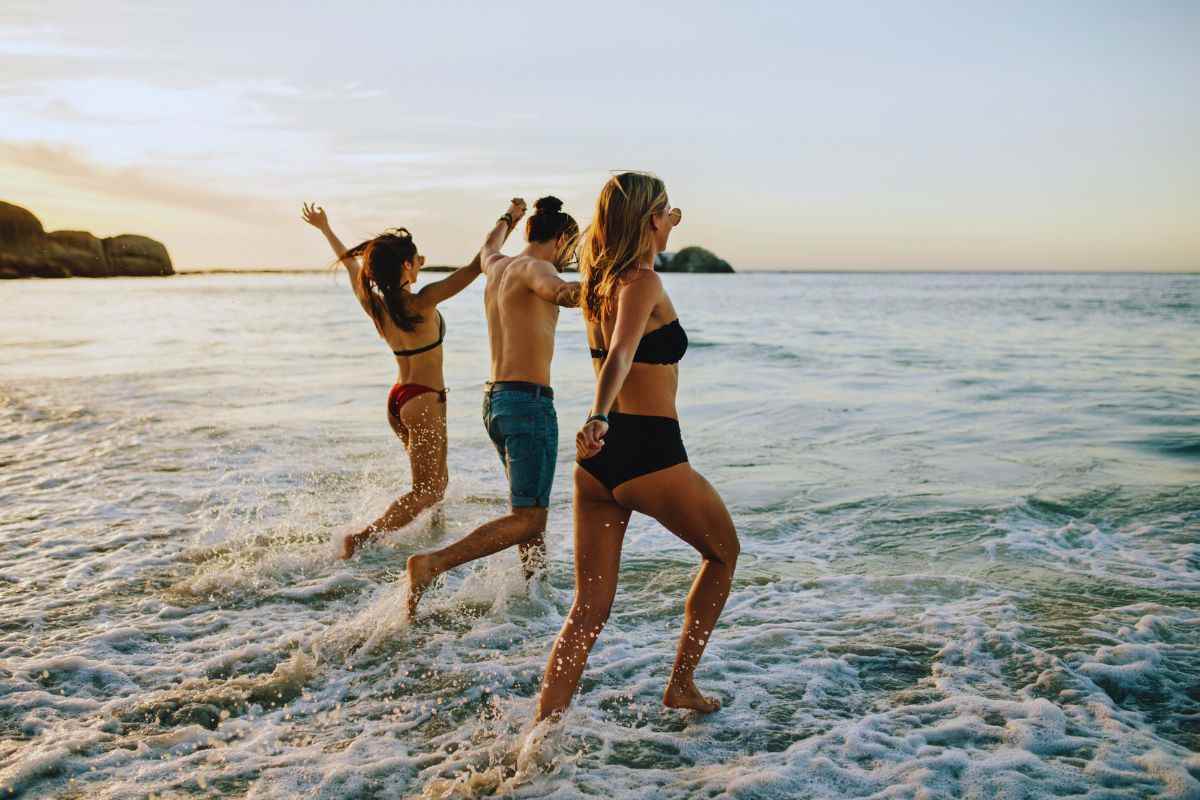 Due ragazze e un ragazzo che entrano in acqua