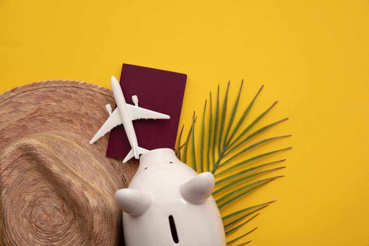 Salvadanaio, cappello, passaporto e aereo in miniatura: viaggi low-cost