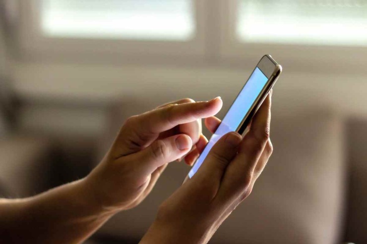 Dito che sta per cliccare sullo schermo del telefono