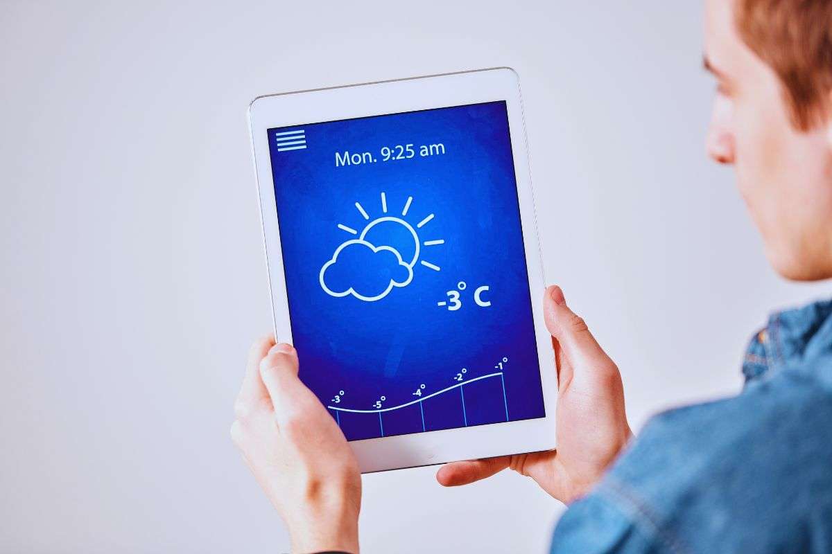 Uomo che guarda app meteo da tablet