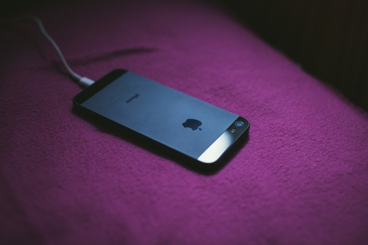 cellulare in carica appoggiato su una superficie viola