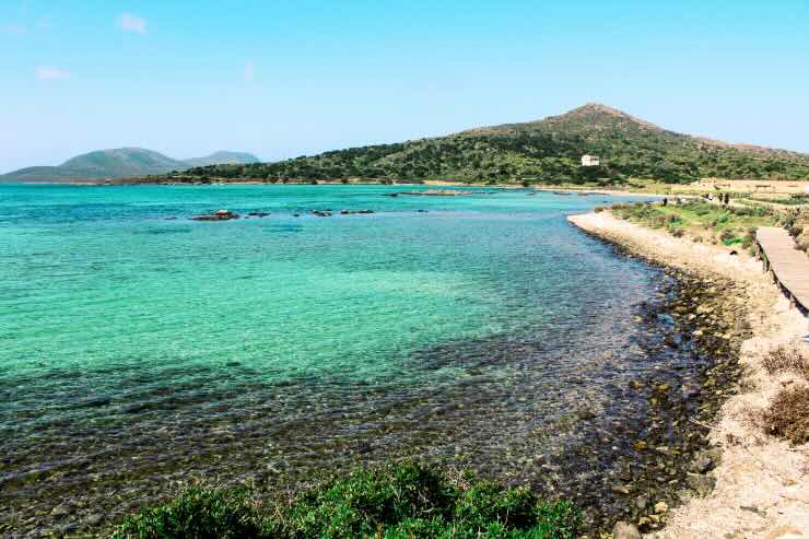 spiaggia di acqua cristallina e montagna all'orizzonte