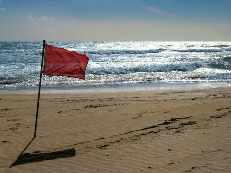 spiaggia con bandiera rossa