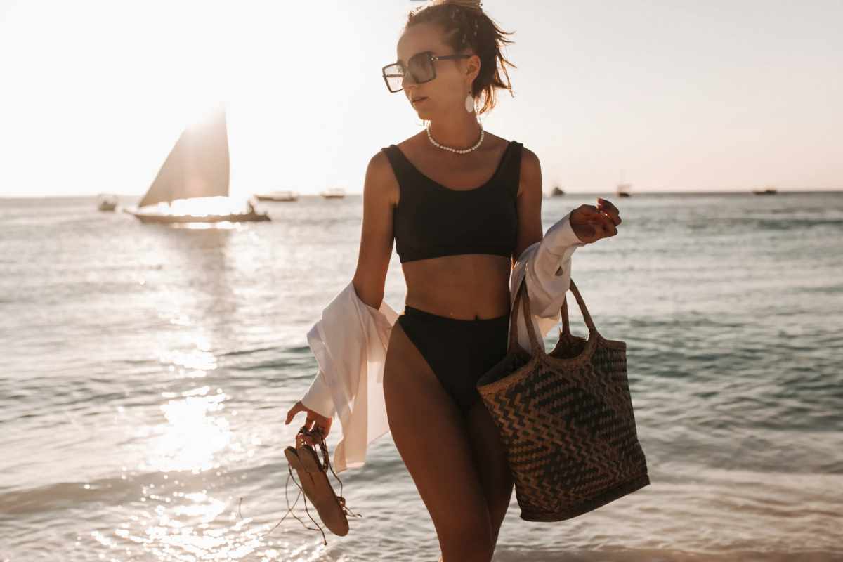 Ragazza in costume che cammina in spiaggia