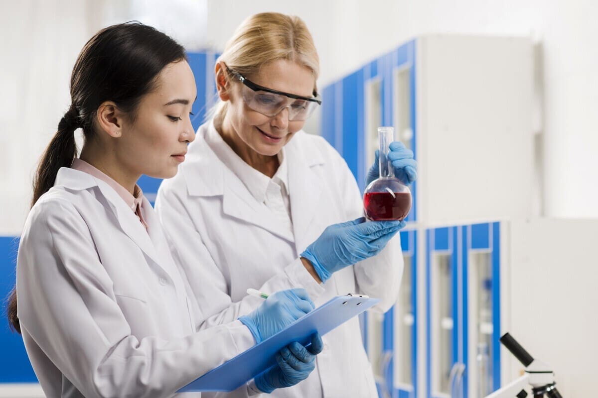 Scienziate che esaminano il contenuto di un matraccio