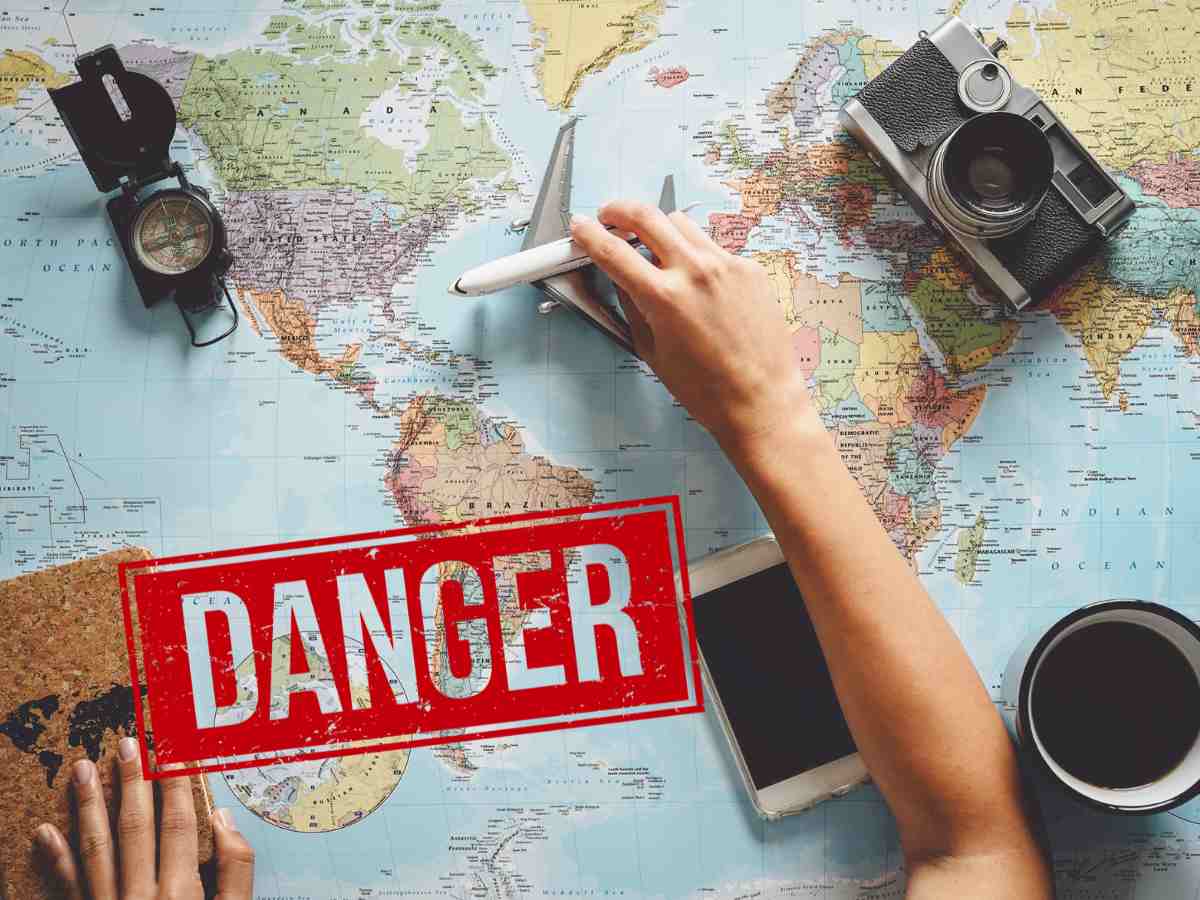 mappamondo con oggetti di viaggio e scritta danger