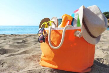 Borsa con oggetti sulla spiaggia