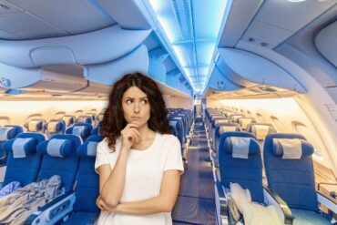 interno di un aereo e donna che pensa