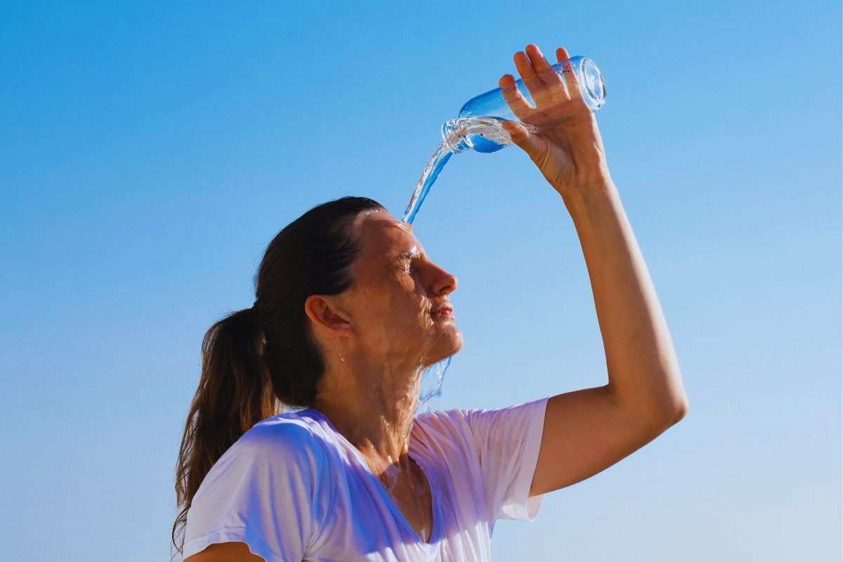 ragazza che si versa acqua addosso
