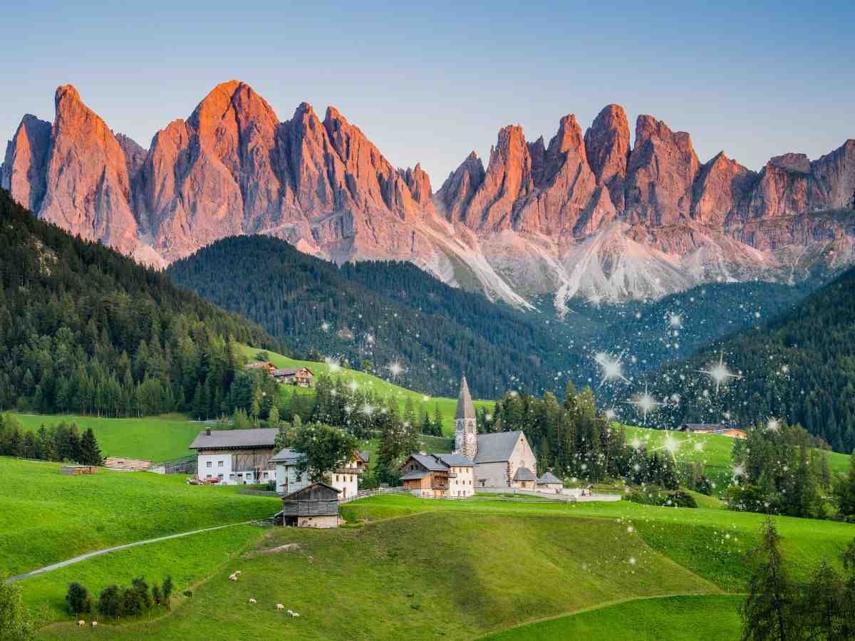 Montagne con Enrosadira e colline verdi con case