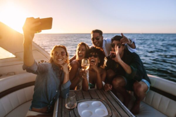 Gruppo di ragazzi in vacanza su una barca che si fa un selfie