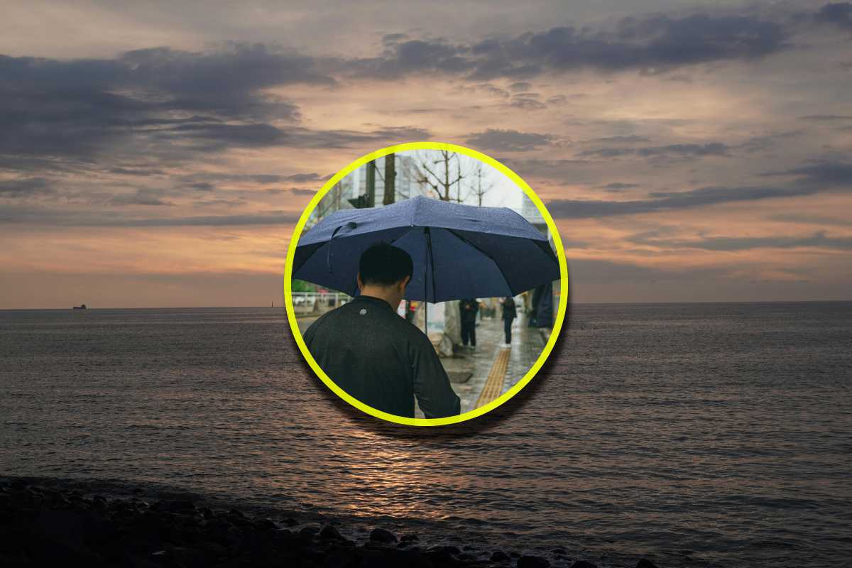 Una foto del mare e in evidenza un uomo con un ombrello