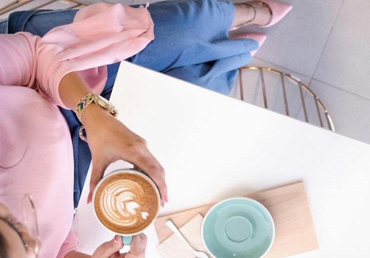 vista dall'alto di una donna con in mano un cappuccino