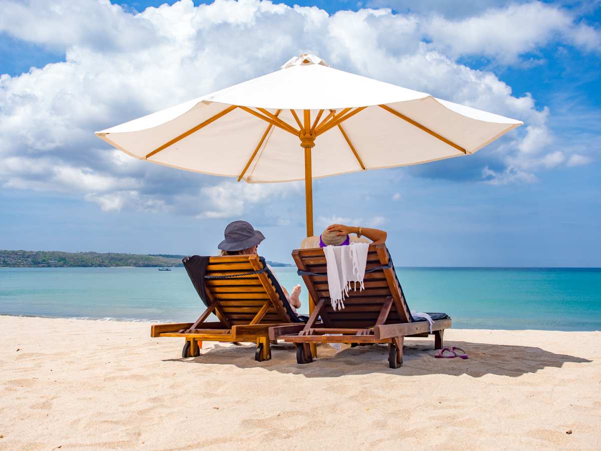 due persone in spiaggia sotto l'ombrellone