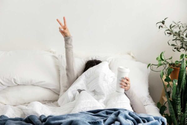 donna a letto con in mano uno smoothie