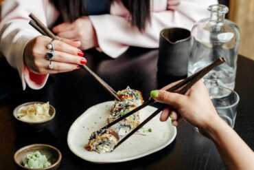 Persone sedute al ristorante giapponese che mangiano