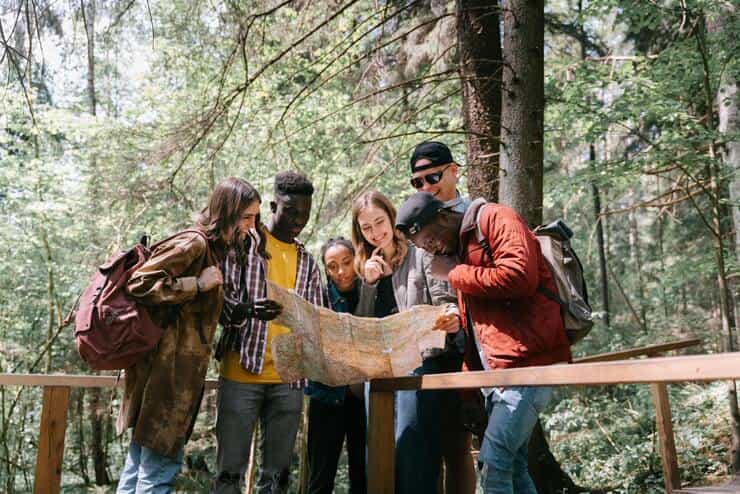 Ragazzi in montagna che guardano una cartina geografica