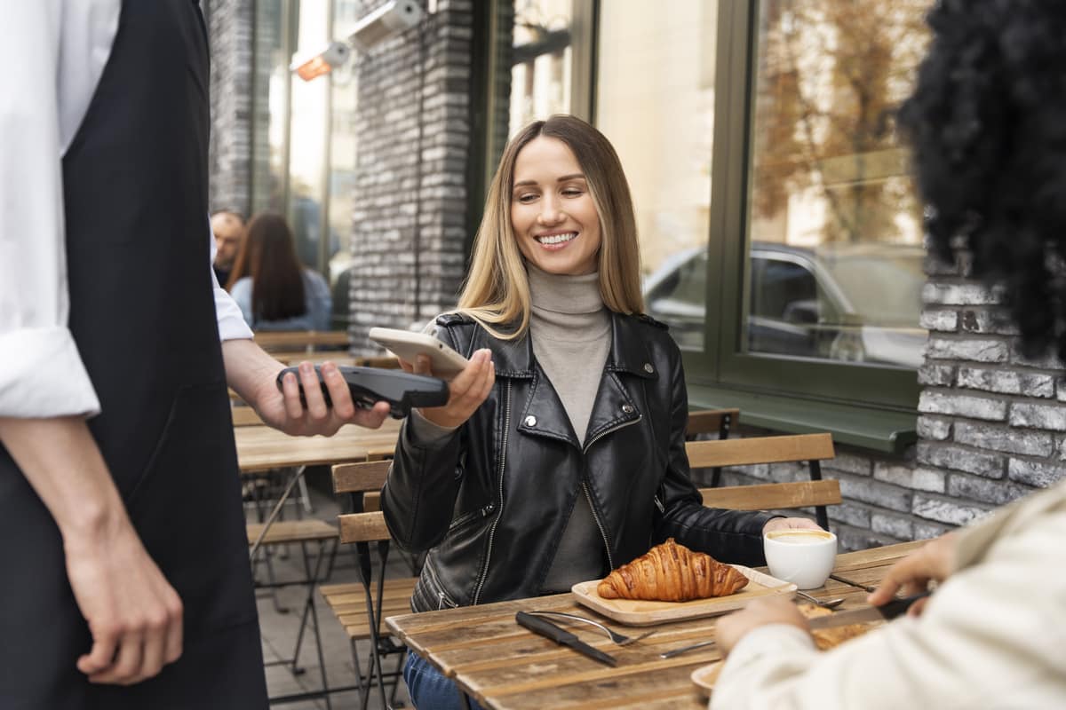 Ragazza paga mentre fa colazione al bar